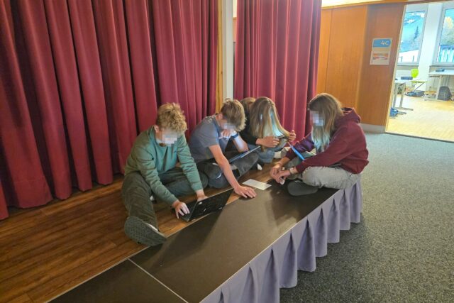 Jugendliche mit Laptops bei einer Projektarbeit