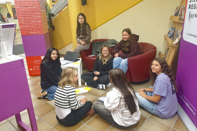 Jugendliche im Kreis sitzend, an einer Projektarbeit